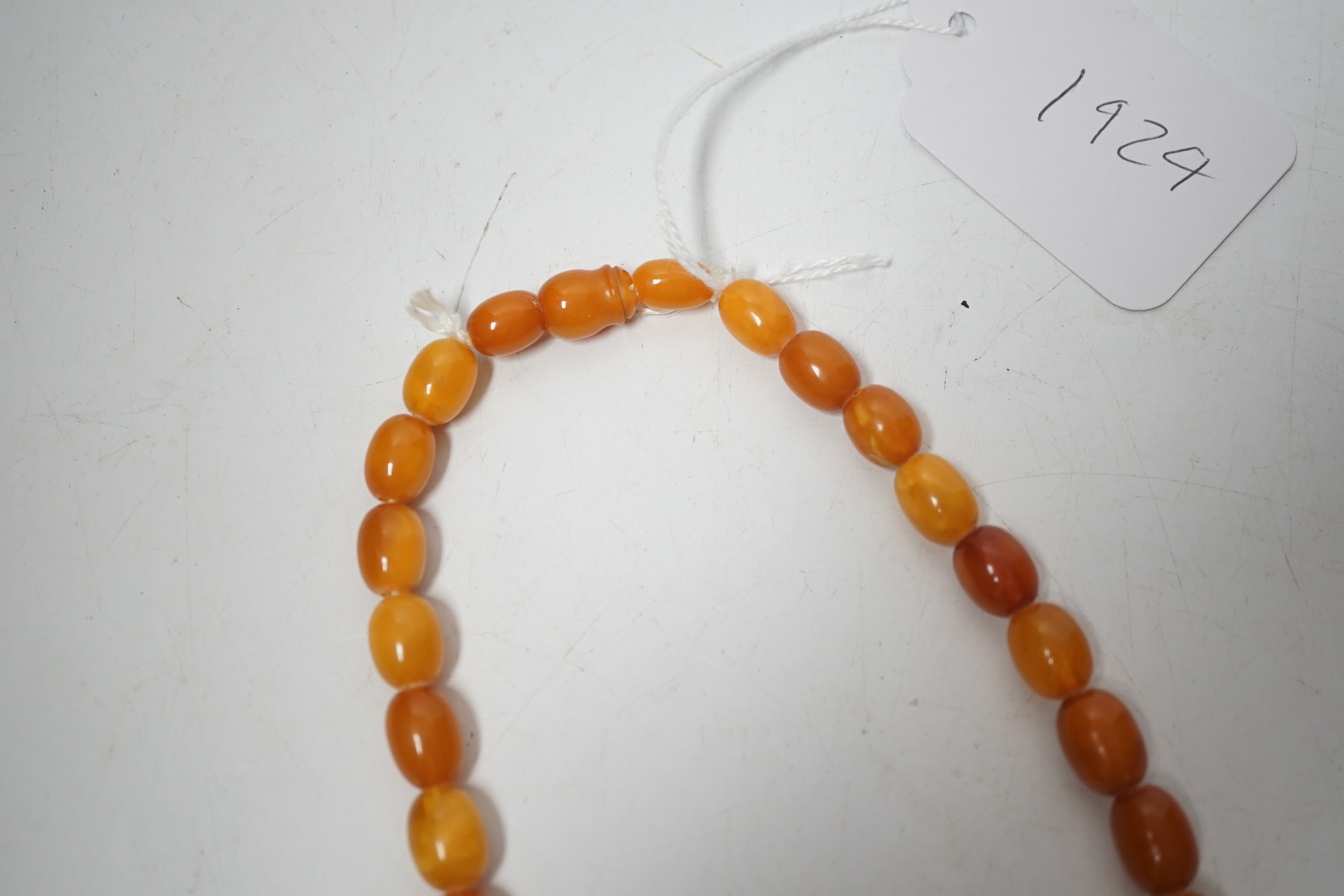 A single strand graduated oval amber bead necklace, 74cm, 83 grams.